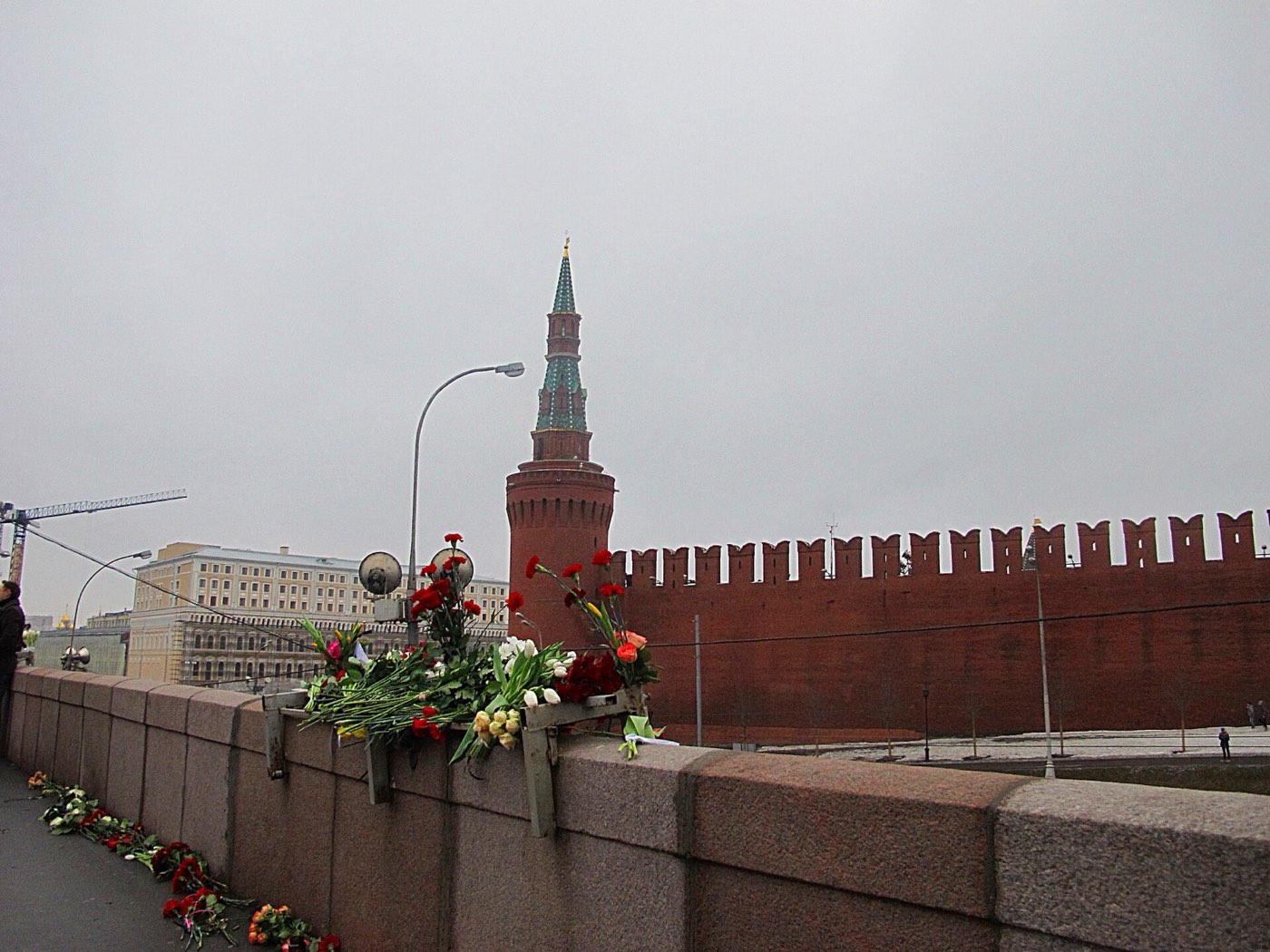 Flowers on the bridge railings, with the Kremlin wall and a tower behind them