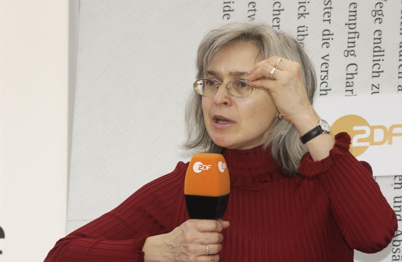 Anna Politkovskaya sitting on a blue sofa and speaking
